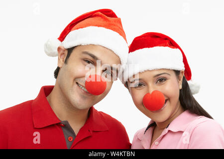 Porträt eines indischen Paares trägt Weihnachtsmütze und lächelnd Stockfoto