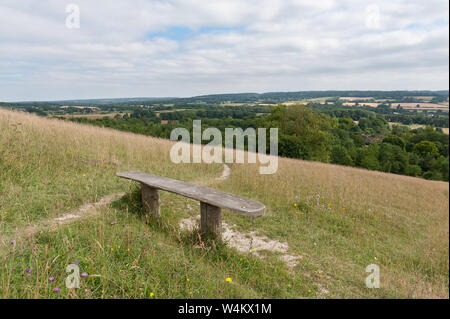 Alte knorrige gebleicht Holzsitz Parkbank, auf einem Hügel in Kreide Grünland nach Süden in Richtung Northdowns, Sevenoaks, Yalding, mit spektakulären Tal Stockfoto