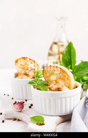 Gebackene Pilze Julienne mit Huhn, Käse und Toast in Töpfen. Stockfoto