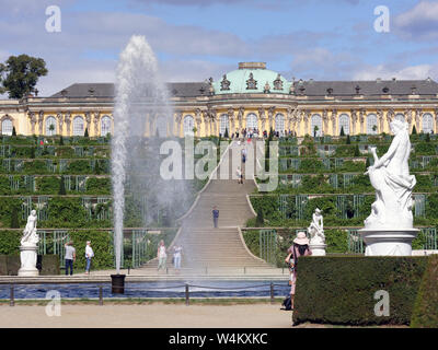 Menschen zu Fuß am Brunnen im Park von Sanssouci gegen Schloss Sanssouci, Potsdam, Deutschland. Der Park ist der Teil des UNESCO-Weltkulturerbe seit 1990 Stockfoto