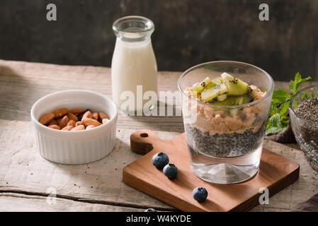 Gesundes Frühstück - Schüssel Müsli, Beeren und Obst, Nüsse, Kiwi, Milch Stockfoto