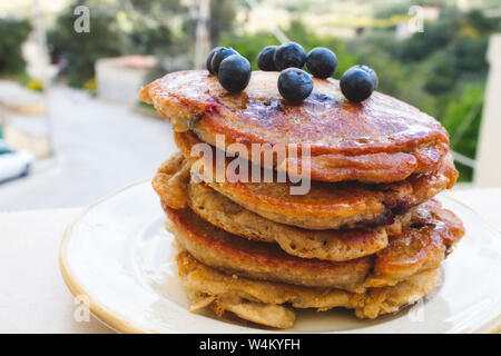 Große Stapel von hausgemachte Pfannkuchen mit Heidelbeeren und Sirup Stockfoto