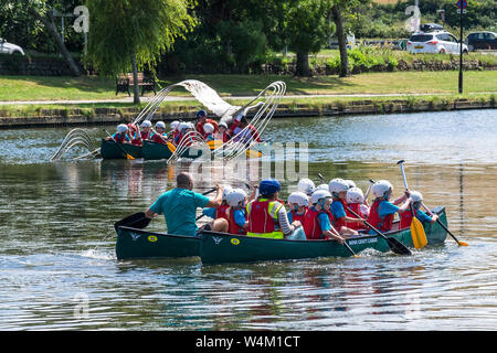 Grundschüler genießen einen freien Ausübung Aktivität Lektion, wie sie Spaß haben, Kanufahren auf trenance Garten See zum Bootfahren in Newquay in Cornwall. Stockfoto