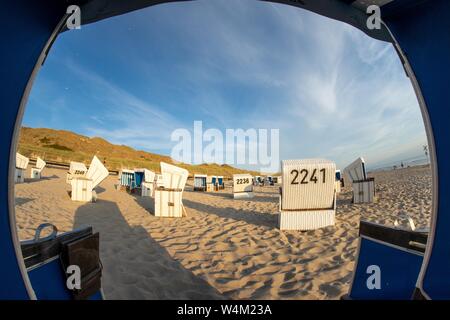 Schöner Sandstrand mit nummerierten Körben um von innen geschossen Ein Zelt Stockfoto
