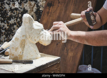 Ein Steinmetz Carving eine Statue von einem Pferd Kopf Stockfoto