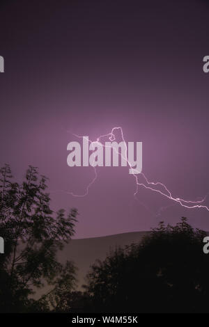 Gewitter mit riesigen Gabel Blitz über ländliche Landschaft in Wales, Großbritannien Stockfoto