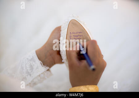 Braut Schuhe Hochzeit Symbol Braut Kleid. Braut schreibt unter Schuh Hochzeit rituellen Aberglauben. Stockfoto