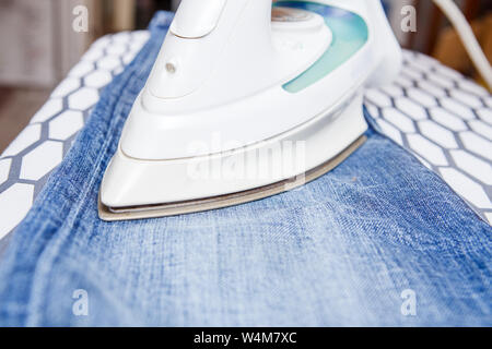 Bild von Mann bügeln Jeans Stockfoto