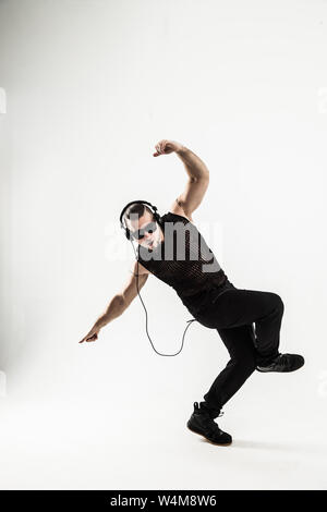 Kreative rapper im Kopfhörer und dunkle Gläser führt eine Rap Song tanzen zu brechen. Foto auf einem weißen Hintergrund und hat einen leeren Raum für Ihre t Stockfoto
