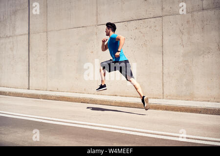 Muskulöse Mann tun Joggen und springen Übungen während im freien Training in der Stadt Stockfoto