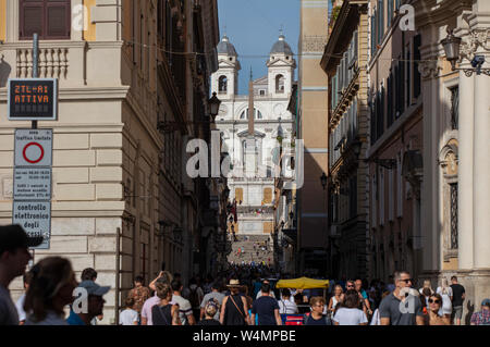 Der Blick entlang der Einkaufsstraße Via dei Condotti auf der Spanischen Treppe und der Kirche Trinità dei Monti im historischen Zentrum der Stadt. Stockfoto
