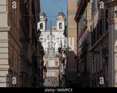Der Blick entlang der Einkaufsstraße Via dei Condotti auf der Spanischen Treppe und der Kirche Trinità dei Monti im historischen Zentrum der Stadt. Stockfoto