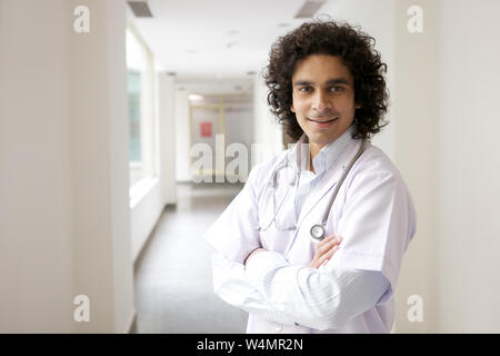 Männlichen Arzt stehend mit seine Arme verschränkt Stockfoto