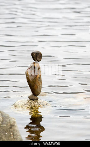 Stein balancing im Loch ein Eilein im Rothiemurchus Wald, Cairngorm, Schottland, Großbritannien. Stockfoto