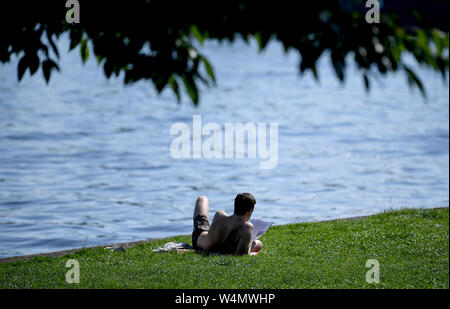 Berlin, Deutschland. 24. Juli, 2019. Ein junger Mann sitzt am Ufer der Spree. Quelle: Britta Pedersen/dpa-Zentralbild/dpa/Alamy leben Nachrichten Stockfoto