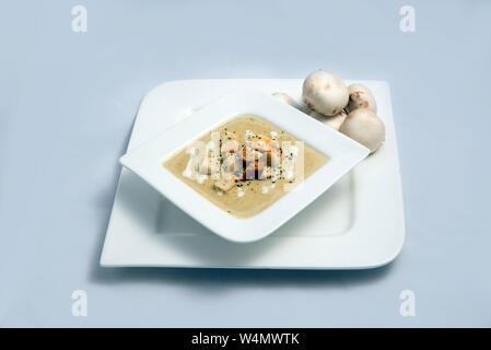 Gegenüber hero Schuß eines Pilzsuppe mit Brotkrumen, Oregano auf einer minimalen weißen Hintergrund mit einem 60°-Winkel auf der Vorderseite Stockfoto