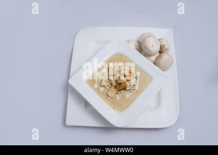 Gegenüber hero Schuß eines Pilzsuppe mit Brotkrumen, Oregano auf einer minimalen weißen Hintergrund mit einem 60°-Winkel auf der Vorderseite Stockfoto