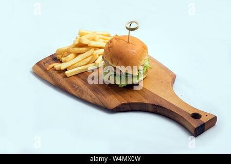 Einen niedrigen Kontrast Held geschossen von einem gegrillten Hähnchen Schieberegler Burger, Pommes auf einer hölzernen platter Board, auf einer minimalen weißen Hintergrund mit einem Winkel von 45 Grad her Stockfoto