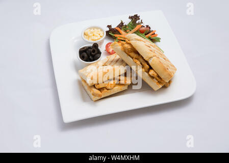 Einen niedrigen Kontrast Held eines Frühstücksplatte mit gegrilltem Huhn panini Sandwich mit Oliven, Käse und Gemüse - Karotte, Tomate, Salat auf einem mi Shot Stockfoto