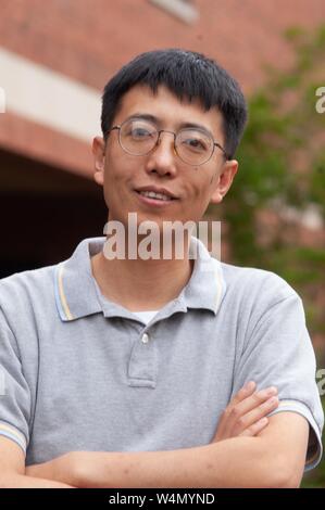 Nahaufnahme der Haiqing Zhao, Professor für Biologie an der Johns Hopkins University in Baltimore, Maryland, draußen stehen und lächelte in die Kamera, 4. Juni 2004. Vom Homewood Sammlung Fotografie. () Stockfoto