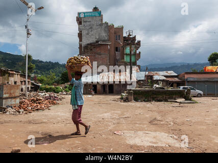 Mann, der einen Korb von Bananen auf seinem Kopf im Dorf Sankhu in Nepal nach dem Erdbeben von 2015. Stockfoto