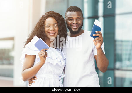 Aufgeregt schwarz Paar hält Pässe und Tickets am Flughafen Stockfoto