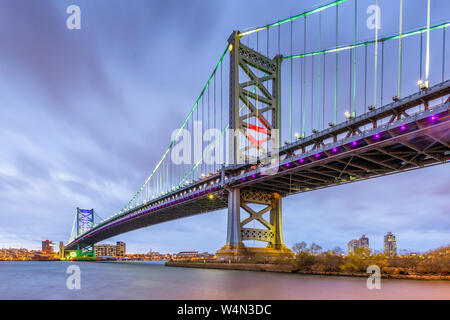 Philadelphia, Pennsylvania, USA Skyline auf dem Delaware River mit Ben Franklin Bridge bei Nacht. Stockfoto