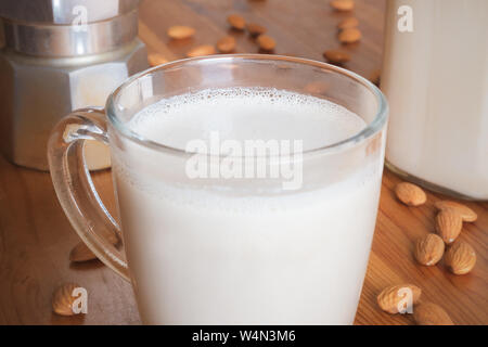 Glas Mandelmilch auf Holz, Tisch, Nahaufnahme. Vegan Mandel Drink in einem jar-pflanzliche Ersatzstoffe für Milcherzeugnisse Stockfoto