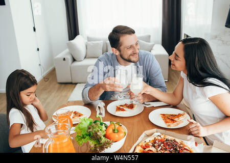 Familie, Mutter, Vater und Tochter beim Essen. Essen essen hausgemachte Pizza zu Hause Stockfoto