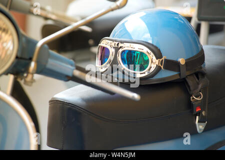 Vespa Piaggio, Italienische Roller mit Helm geparkt in einer Straße Stockfoto