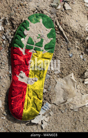 Die Fahne von Benin ist auf der Sohle eines alten Boot dargestellt. Ökologie Konzept mit Umweltverschmutzung von Haushalts- und Industrieabfällen. Stockfoto