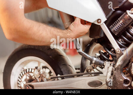 Mechaniker close up Reparatur Motorrad in der Werkstatt. Stockfoto