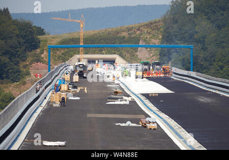 Zeltingen Rachtig, Deutschland. 24. Juli, 2019. Arbeitnehmer, die Asphaltierung der Straße Oberfläche des Hochmosel Brücke im Bau bei Temperaturen weit über 30 Grad Celsius. Es gibt keine schattigen Platz auf dem 160 Meter hohen Gebäude über dem Moseltal. Quelle: Thomas Frey/dpa/Alamy leben Nachrichten Stockfoto