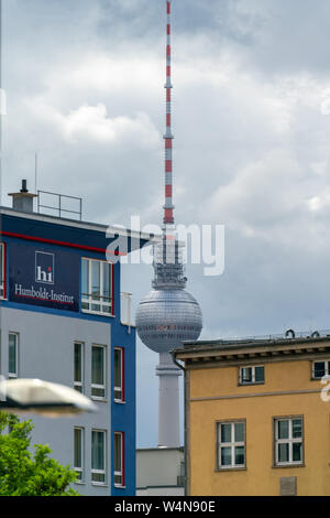 Elisabeth-Schwarzhaupt-Platz, Nordbahnhof, Berlin, Deutschland - Juli 07, 2019: Blick auf den Fernsehturm in der Ferne durch eine Lücke zwischen einem blauen und einem y Stockfoto