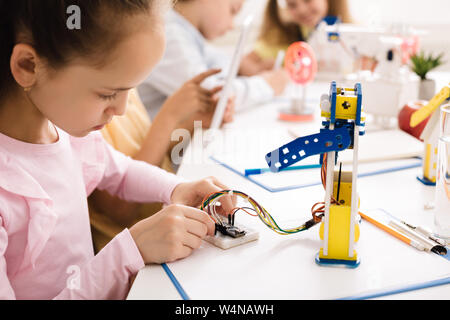 Mädchen bauen Roboter, die mit Drähten in der Klasse Stockfoto