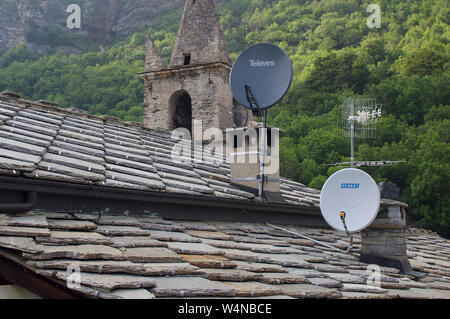 Satellitenschüsseln auf dem Dach des alten Hauses in Montceniso Italien Stockfoto