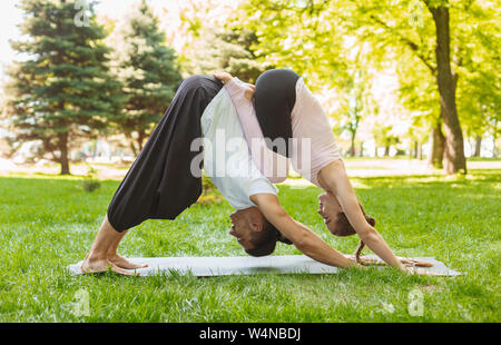 Yoga zusammen. Paar der jungen Leute üben acroyoga im Freien Stockfoto