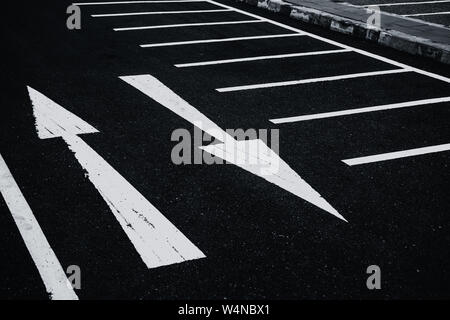 2 weisen zwei Richtungen Pfeile Farbe auf Asphalt. Konflikte Verwirrung Konzept. Stockfoto