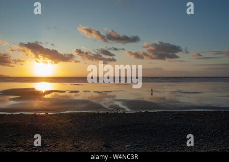 Paar entlang Westward Ho! Strand bei Sonnenuntergang Stockfoto