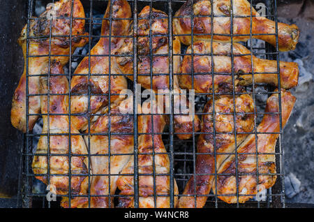 Grill: Stücke von Hähnchen Fleisch auf dem Grill über die Kohlen mit gebratenen Zwiebeln Stockfoto