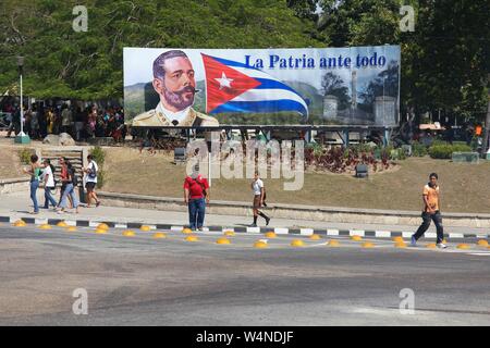 SANTIAGO DE KUBA - 10. FEBRUAR 2011: die Menschen laufen durch patriotische Propaganda Zeichen in Santiago de Cuba. Die Kubanische Revolution von 1953-1959 erhöhte Bedeutung o Stockfoto