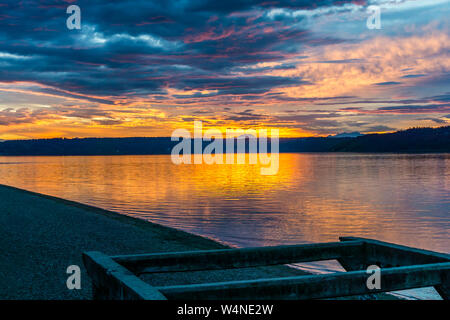 Die Wolken hängen am Himmel, wie die Sonne hinter den Olympic Mountains im Armaturenbrett, Washington. Stockfoto