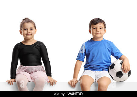 Kleine Ballerina Mädchen und einen kleinen Fußballer sitzen auf einem Panel, und wenn man die Kamera auf weißem Hintergrund Stockfoto