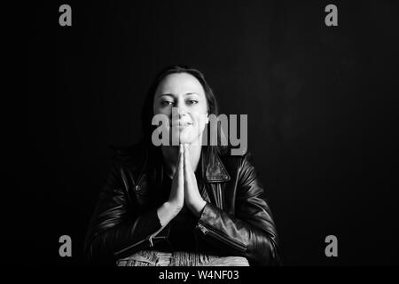 Studio Portrait einer attraktiven jungen Frau in schwarzem Leder Jacke gegen einen einfachen Hintergrund Stockfoto