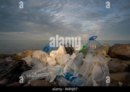 Dirty Plastikflaschen auf den Stein Strand. Umweltverschmutzung. Stockfoto