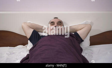 Ein älterer Mann liegt in seinem Bett einschlafen, Erwachen aus einem Traum, Furcht, Angst Stockfoto
