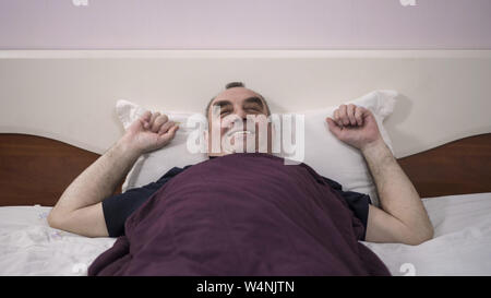 Ein älterer Mann liegt in seinem Bett einschlafen, Erwachen aus einem Traum, Furcht, Angst Stockfoto