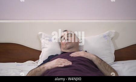 Ein älterer Mann liegt in seinem Bett einschlafen, Erwachen aus einem Traum, Furcht, Angst Stockfoto