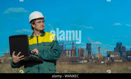 Die männlichen Ingenieur Projekte die Arbeit. Sonne und Wolken. Der Mann befindet sich in einer grünen sunglass Weste gekleidet Stockfoto