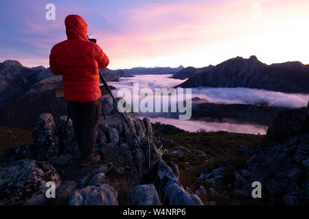 Man Nebel fotografieren bei Sonnenaufgang vom Gipfel der Berge Stockfoto